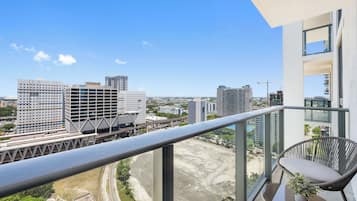 Un balcon offrant une vue sur le paysage urbain, avec notamment des immeubles de grande hauteur et un pont.