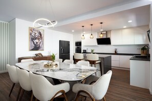 A modern kitchen with white cabinetry, a black refrigerator, and a built-in oven. - Luxury Villa with Private Pool Near Faro Beach, Offering Unparalleled Comfort! (Faro)