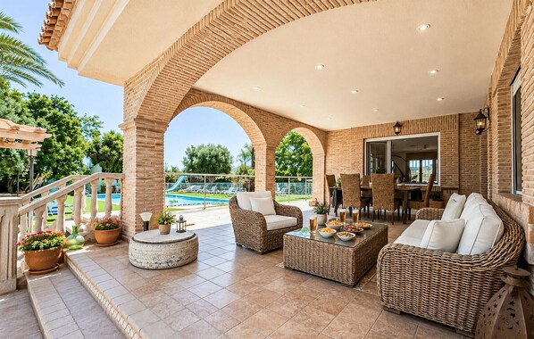 A covered outdoor area with wicker furniture, a pool, and a view of the pool. - Lovely home in Murcia (Murcia)