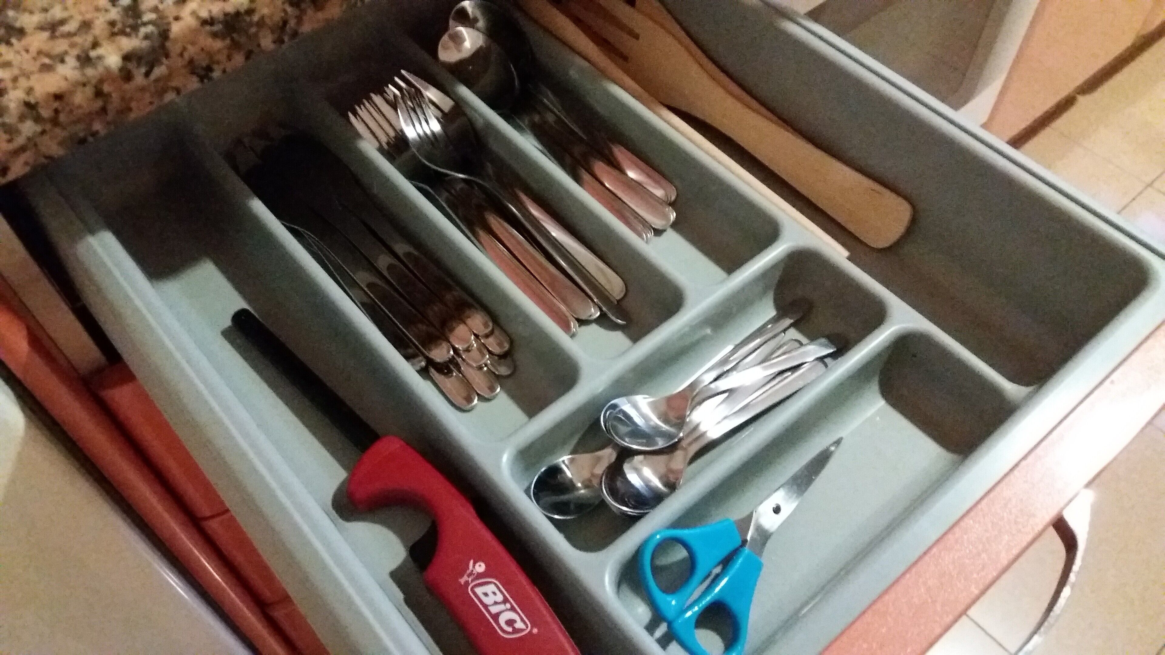 Un tiroir compartimenté contenant divers ustensiles et outils.