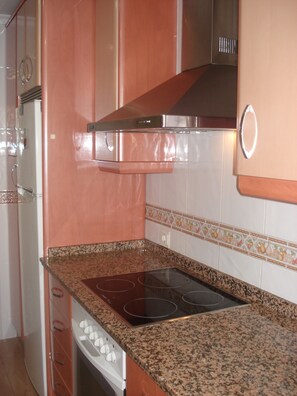 A kitchen with a built-in stove, stainless steel range hood, and a microwave.