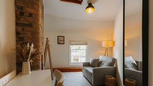 A cozy living room with a sofa, a table, and a lamp.