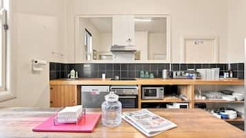 A kitchen with a wooden countertop, a microwave, a dishwasher, and a sink.