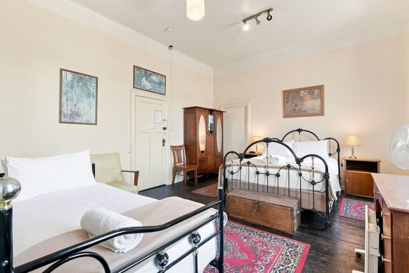 A hotel room with a bed, a chest of drawers, a desk, and a chair.
