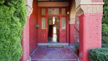 A red brick building entrance with a number '211' above the door.