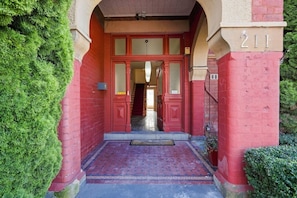 A red brick building entrance with a number '211' above the door. - Edinburgh Family + Ensuite | Hobart CBD (Hobart)