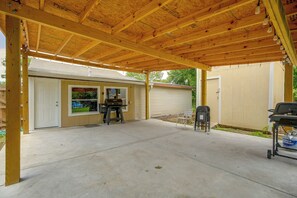 A covered patio area with a concrete floor, a barbecue grill, and a seating area. - Near San Antonio River Walk w/ Fenced Yard (San Antonio)