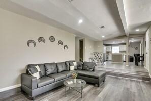A modern living room with a sectional sofa, a coffee table, and decorative wall art. - 6BR House w/ Massive Parking, Centrally Located (Houston)