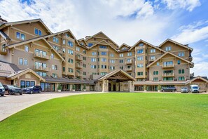 Ein mehrstöckiges Hotel mit Innenhof, Außenbestuhlung und Parkplatz.