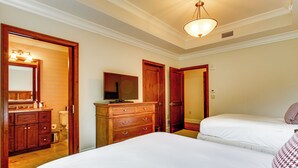 Habitación de hotel con una cama grande, un aparador, un espejo y un televisor.