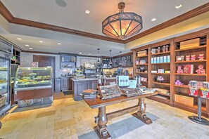 A café interior with a central island, a cash register, a menu board, and shelves stocked with snacks and beverages. - Ski-in/ski-out! Mtn-view Montage Deer Valley Condo (Park City)