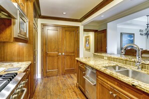 A kitchen with wooden cabinets, granite countertops, a stainless steel sink, and a dishwasher. - Ski-in/ski-out! Mtn-view Montage Deer Valley Condo (Park City)