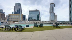 A rooftop pool area with lounge chairs and a view of surrounding high-rise buildings. - Explore Dtwn Austin! Luxe High-rise Escape w/ Pool (Austin)