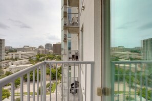 Ein Hochhaus mit einem Balkon und Blick auf eine Stadtlandschaft.