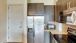 A modern kitchen with stainless steel appliances, a water dispenser, and a toaster. - Explore Dtwn Austin! Luxe High-rise Escape w/ Pool (Austin)