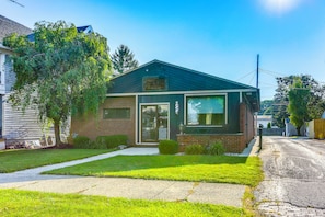 A small, single-story building with a brick facade and a green roof, featuring a large window and a visible sign. - My Story - Walkable Dtwn Tiffin Apt With Character (Tiffin)