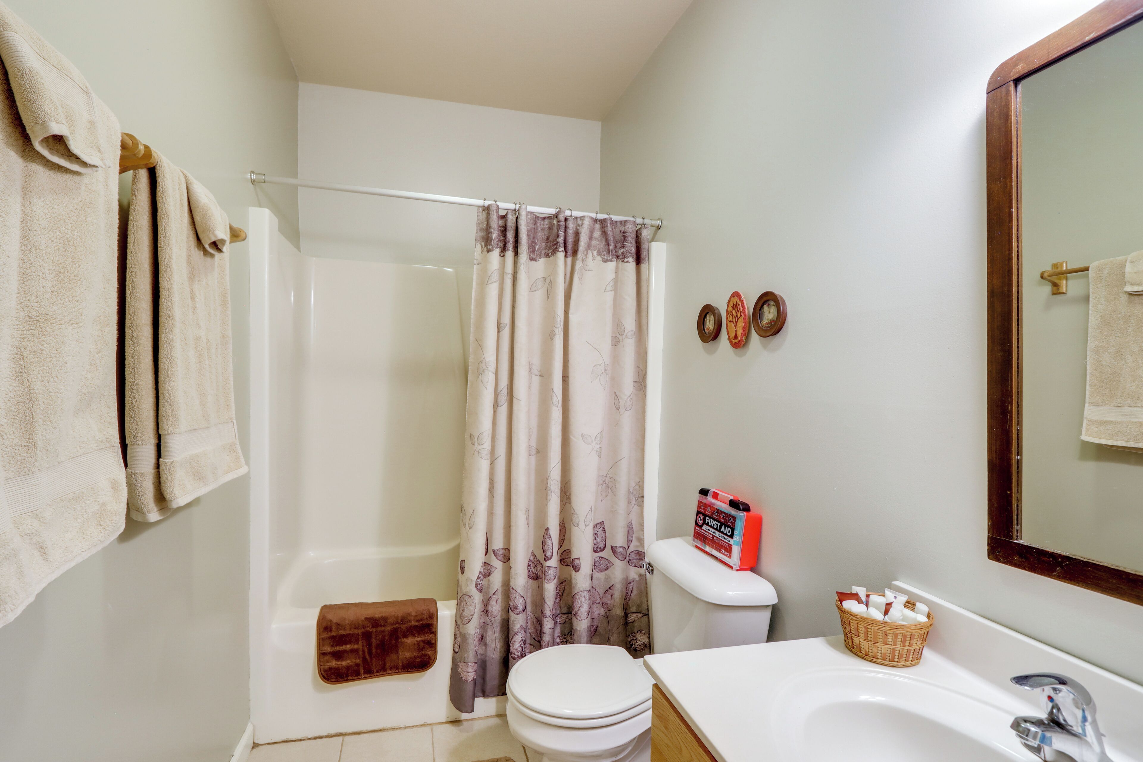 A bathroom with a shower, toilet, and sink.