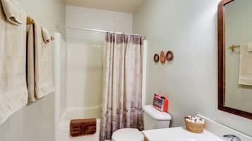 A bathroom with a shower, toilet, and sink.