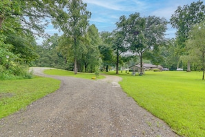 A gravel path leading to a house surrounded by lush greenery and trees. - Adventure Base in Andrews: Cozy Family Apt (Andrews)