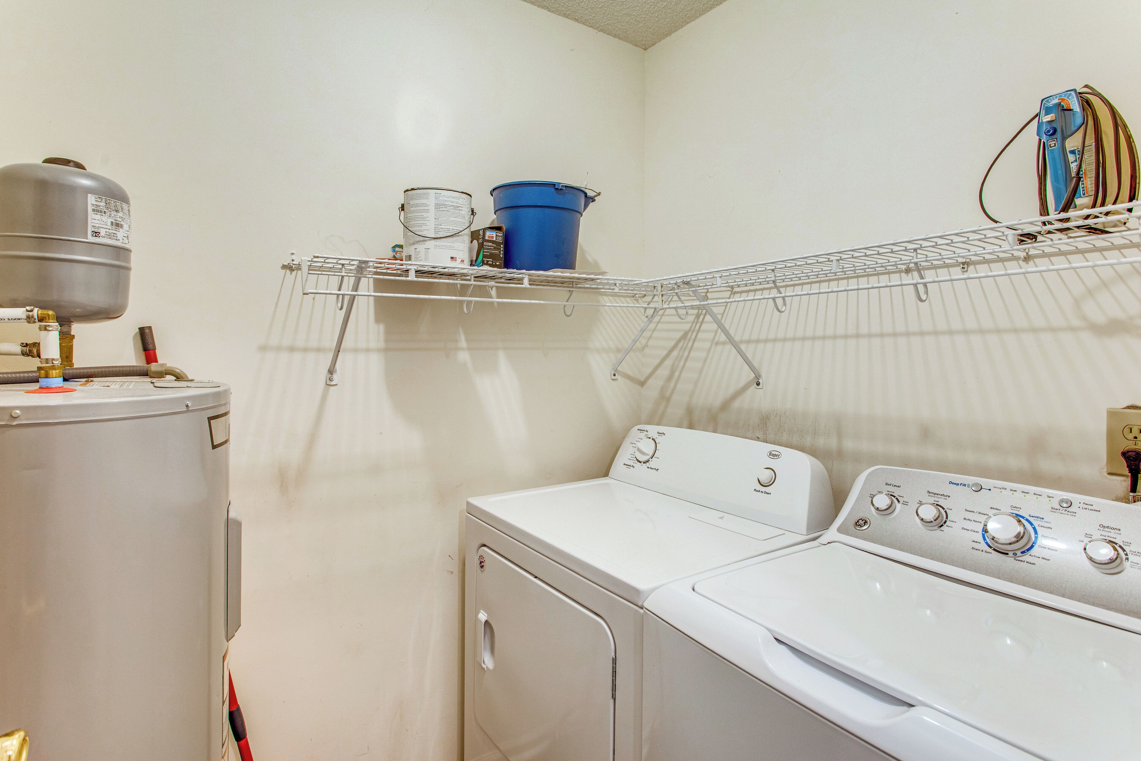 A laundry room with a washing machine, dryer, and a water heater.