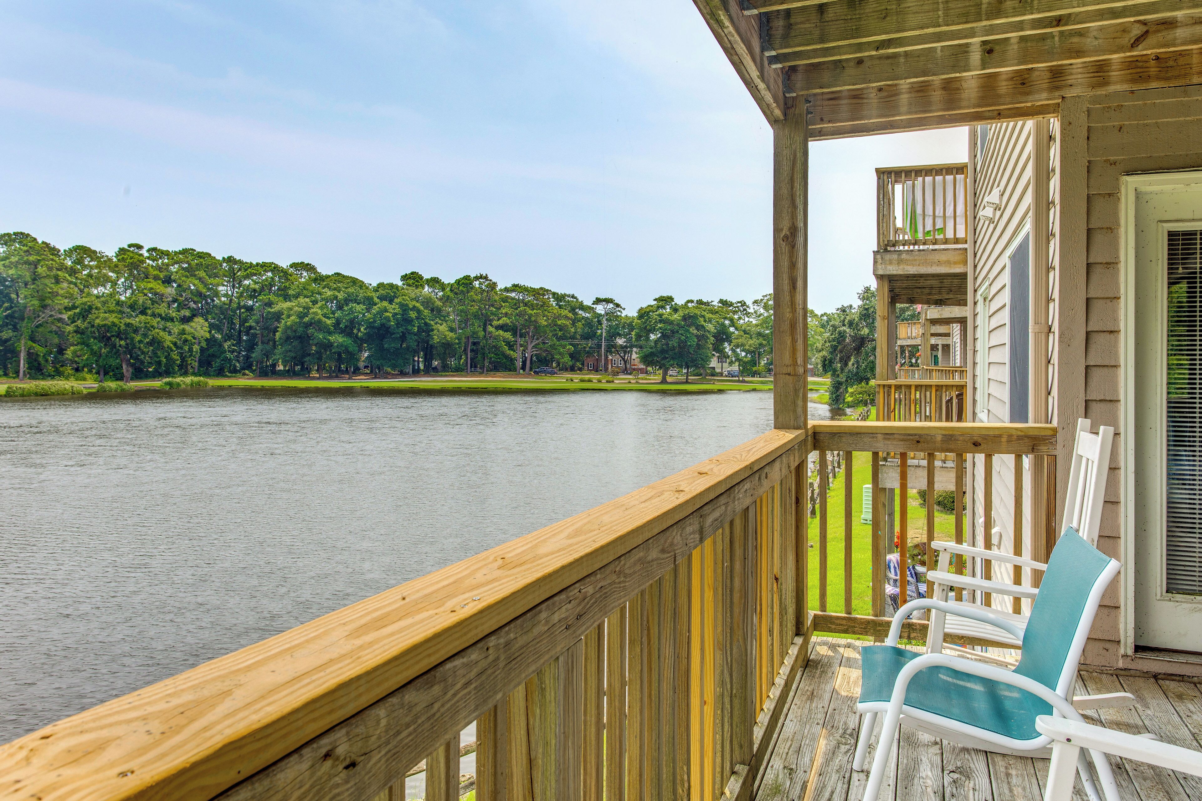 A wooden deck with a view of a lake and trees.