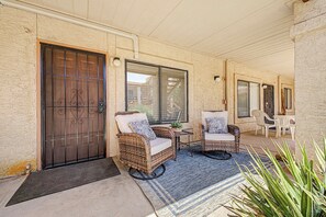 A covered patio area with wicker furniture, a door, and windows. - Pool & Hot Tub Access! Superstition Mtn Condo (Apache Junction)