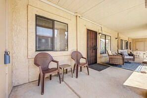 A covered outdoor seating area with wicker furniture, a door, and windows. - Pool & Hot Tub Access! Superstition Mtn Condo (Apache Junction)