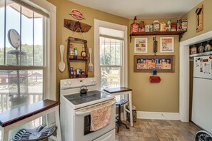 A kitchen with a stove, oven, and various kitchen items on the wall. - Walk to Bathhouse Row! Historic Gem w/ Yard (Hot Springs)