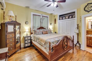 A bedroom with a wooden bed, a nightstand, a dresser, a ceiling fan, and a wardrobe. - Walk to Bathhouse Row! Historic Gem w/ Yard (Hot Springs)
