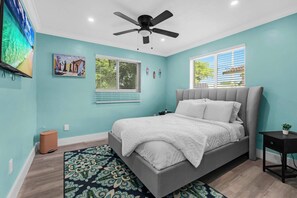 A bedroom with a bed, a ceiling fan, a window with blinds, and a wall-mounted TV. - < 3 Mi to Hard Rock Stadium! Family-friendly Home (Miami Gardens)