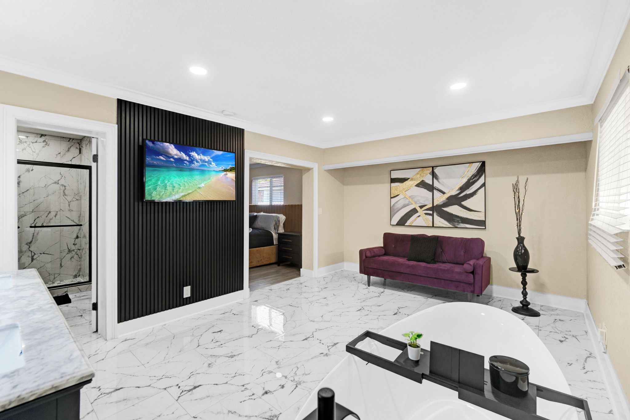 Una sala de estar moderna con piso de mármol, un televisor de pantalla plana, un sofá púrpura y un cuadro en la pared.