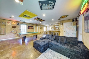 A room with a pool table, a sofa, and a dartboard. - Shared BBQ Area & Pool! Cozy Home in Lake Charles (Lake Charles)