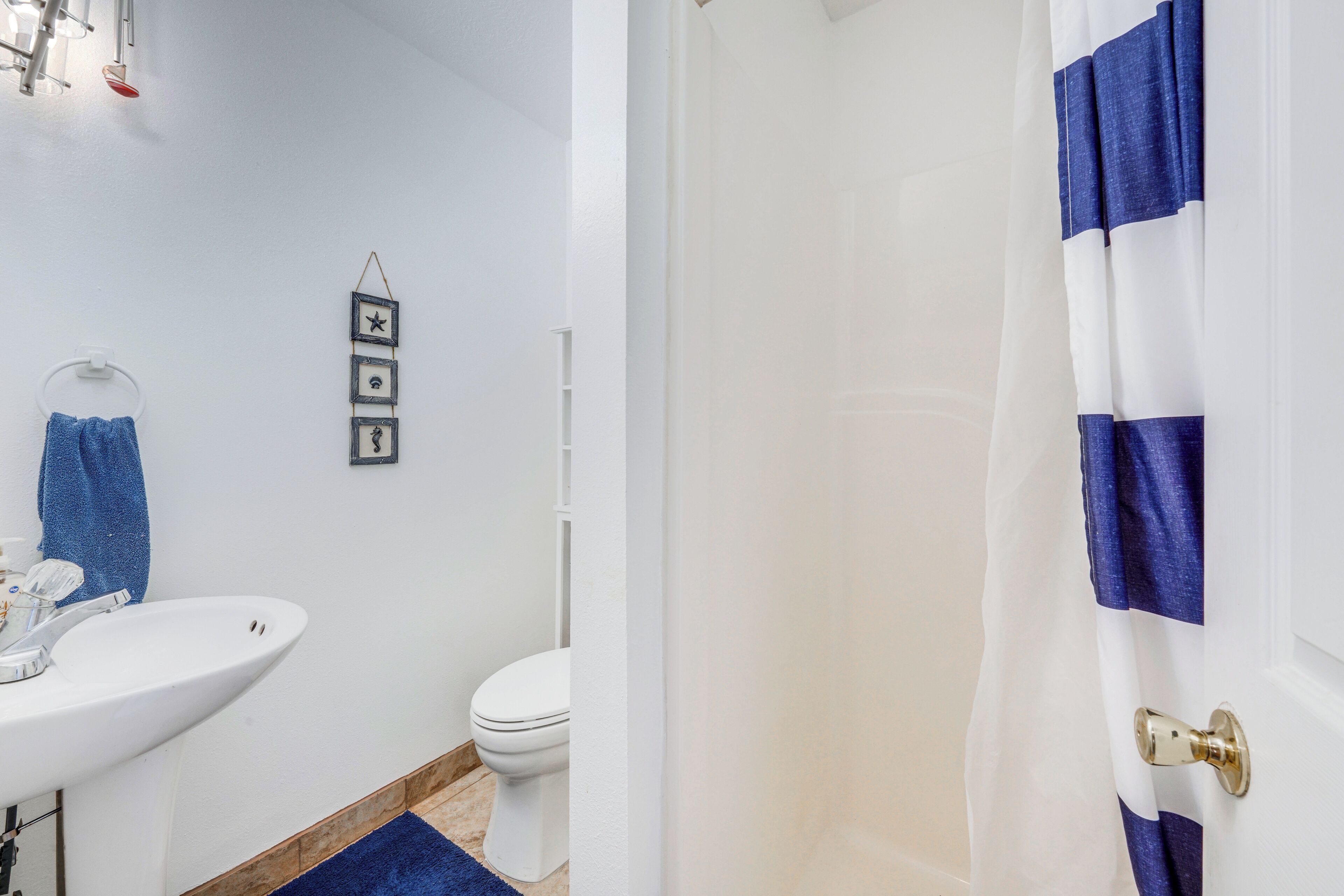 A bathroom with a white sink, toilet, and shower curtain.