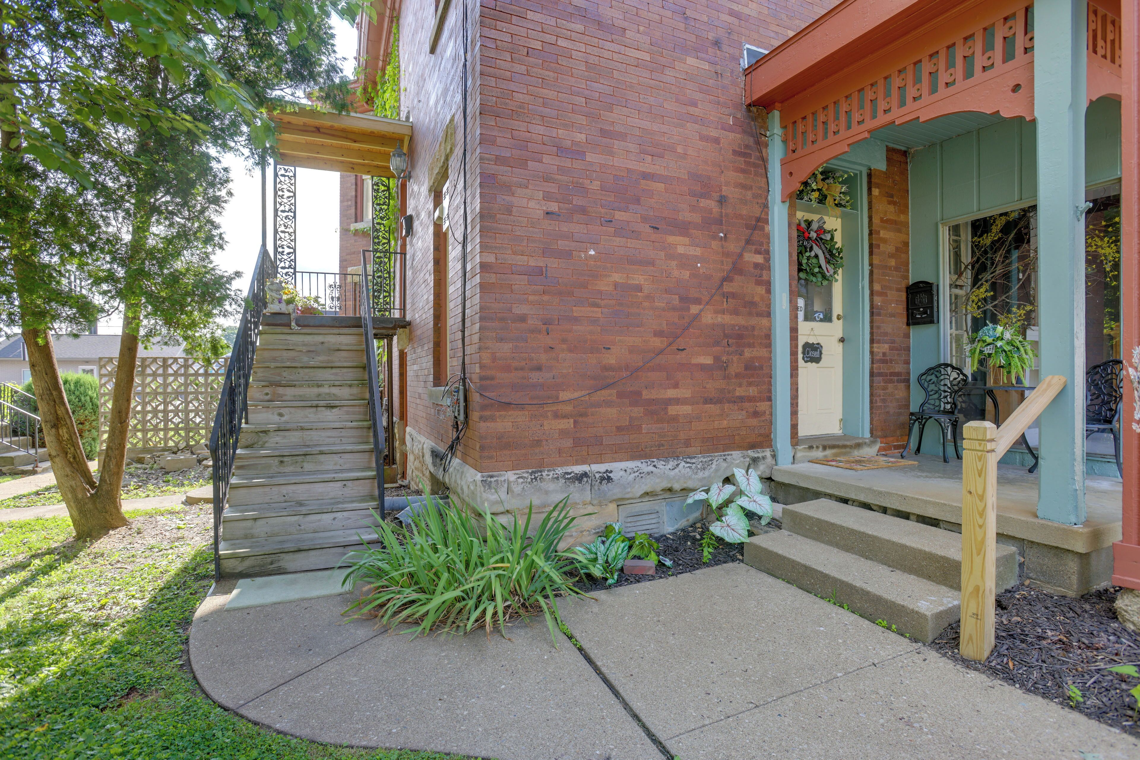 A brick building with a wooden staircase leading to a porch.