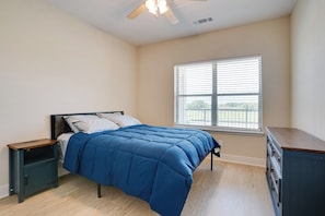 A bedroom with a bed, a nightstand, a dresser, a window with blinds, and a ceiling fan. - 2 Mi to Dtwn Crowley! 3-unit Rental (Crowley)