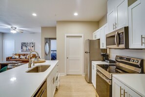 A modern kitchen with white cabinets, stainless steel appliances, and a central island with a sink. - 2 Mi to Dtwn Crowley! 3-unit Rental (Crowley)