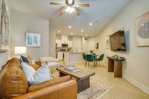 A modern living room with a leather sofa, a wooden coffee table, and a dining area with green chairs. - 2 Mi to Dtwn Crowley! 3-unit Rental (Crowley)