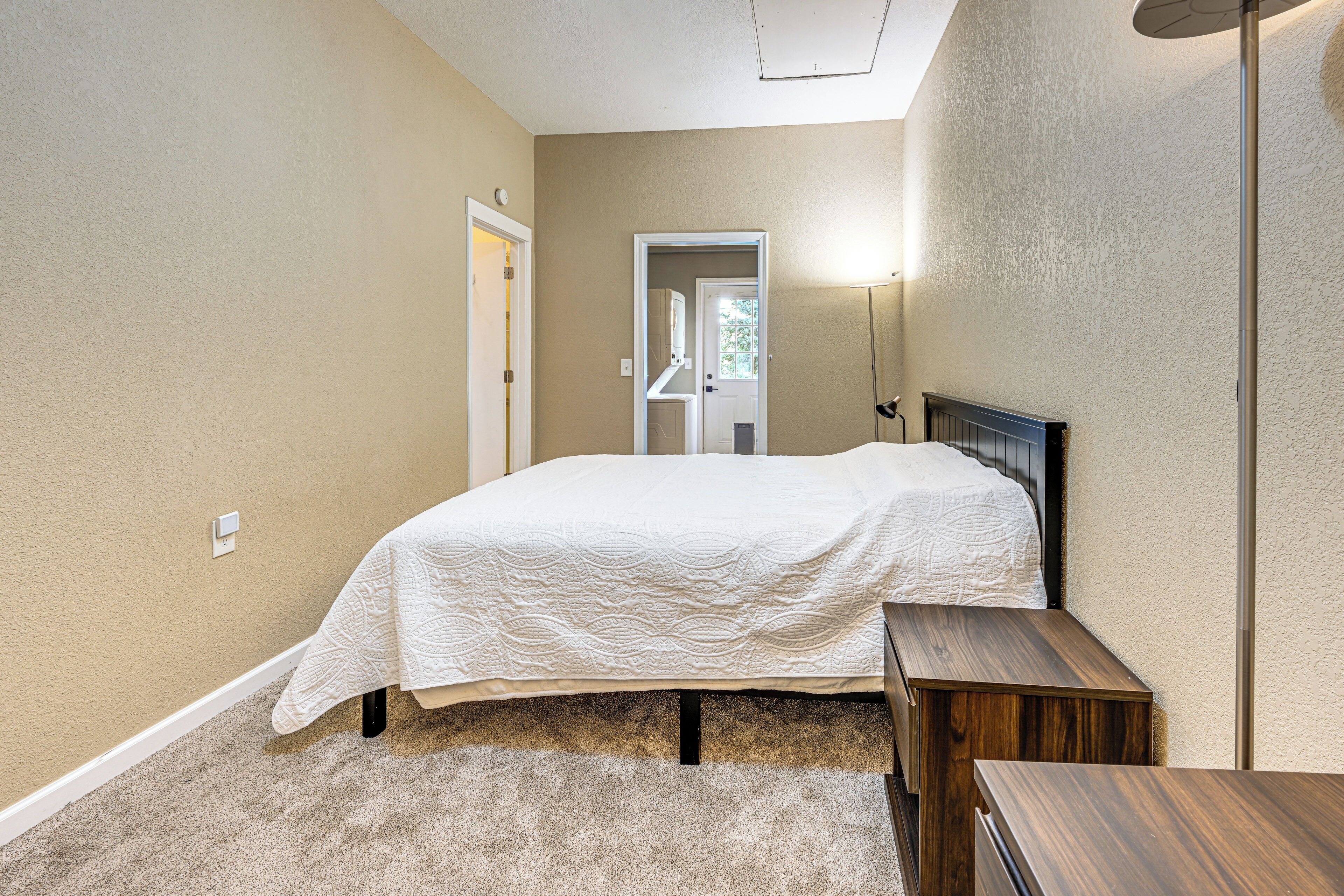 A bedroom with a bed, bedside table, and a lamp.
