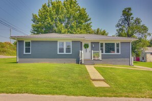 A single-story house with a front porch, a small front yard, and a metal roof.