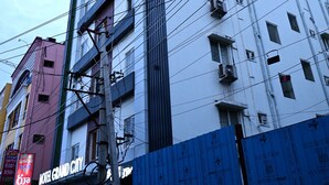A multi-story hotel building with a modern facade, multiple balconies, and visible air conditioning units. - HOTEL GRAND CITY (Vijayawada)