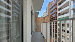 A narrow corridor with a glass railing on one side and a metal railing on the other, leading to a building with multiple balconies. - Apartment on the Coast for 6 People (Middelkerke)