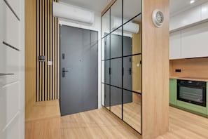 A modern kitchen with a built-in oven and a wooden cabinet. - RentPlanet - Apartamenty Kapitanat (Gdańsk)