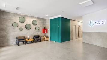 A modern interior with a reception desk, seating area, and a wall-mounted sign for 'Mindeli's Diamond'.
