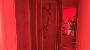 Une salle de bain avec douche, toilettes et lavabo.