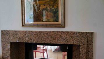 A fireplace with a framed painting above it.