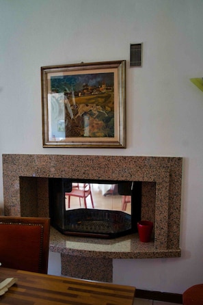 A fireplace with a framed painting above it.
