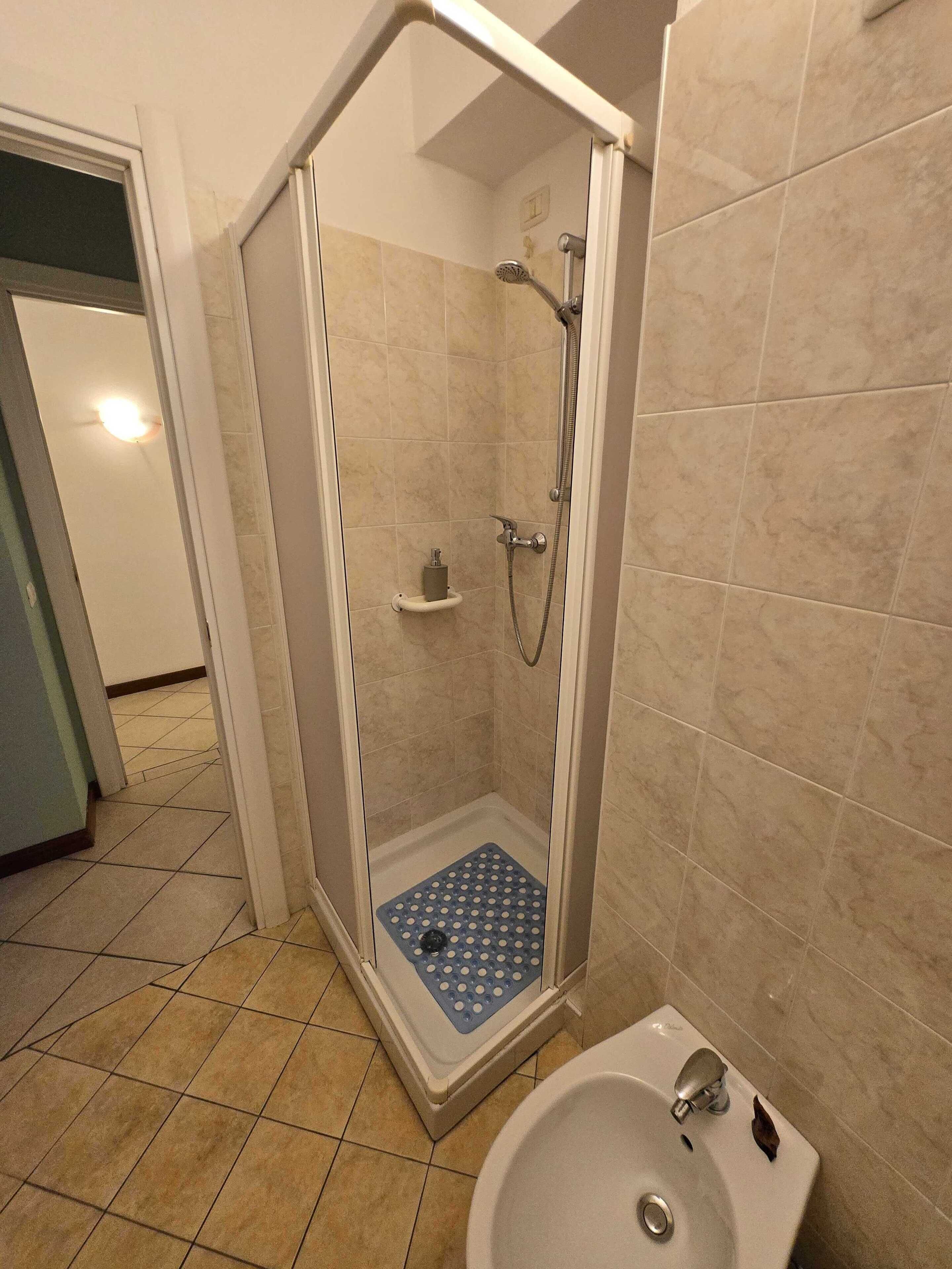 Un bagno con box doccia, lavandino e WC.