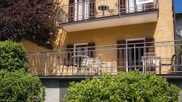 Un bâtiment à deux étages doté d’un balcon, de mobilier d’extérieur et d’un espace jardin.