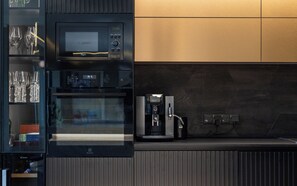 A modern kitchen with a built-in microwave, oven, and coffee machine. - Luxury Pool & Sauna Villa Roiu (Roiu)