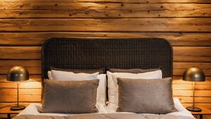 A bed with a dark headboard, white bedding, and two lamps on either side. - Skýra Retreat (Rovaniemi)
